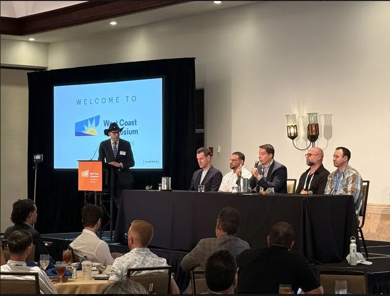 A panel on stage at the West Coast Symposium